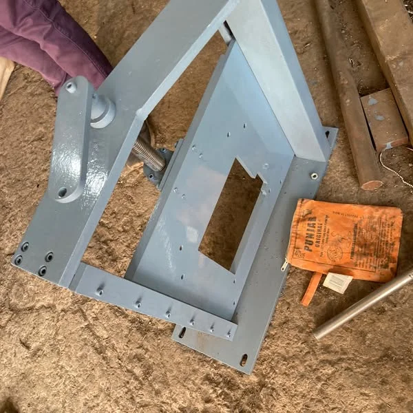 A grey metal guide stand with a rectangular opening and machined mounting holes.