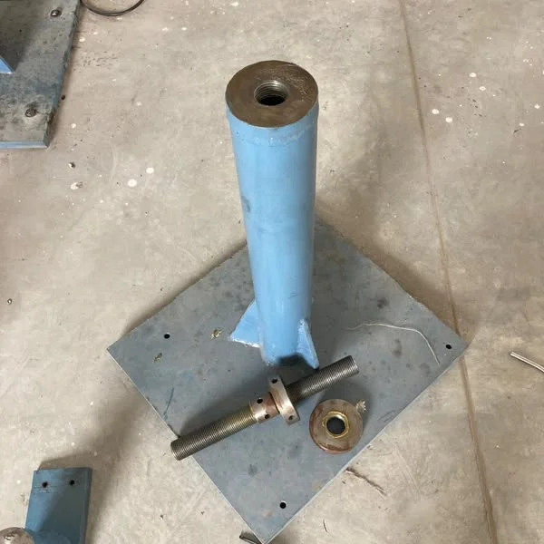 A painted shaft support, plates, and smaller machined components.